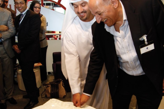 Helal Al Marri and Ali Baghdadi cut the cake at Aptec’s stand yesterday. Aptec maintains its record